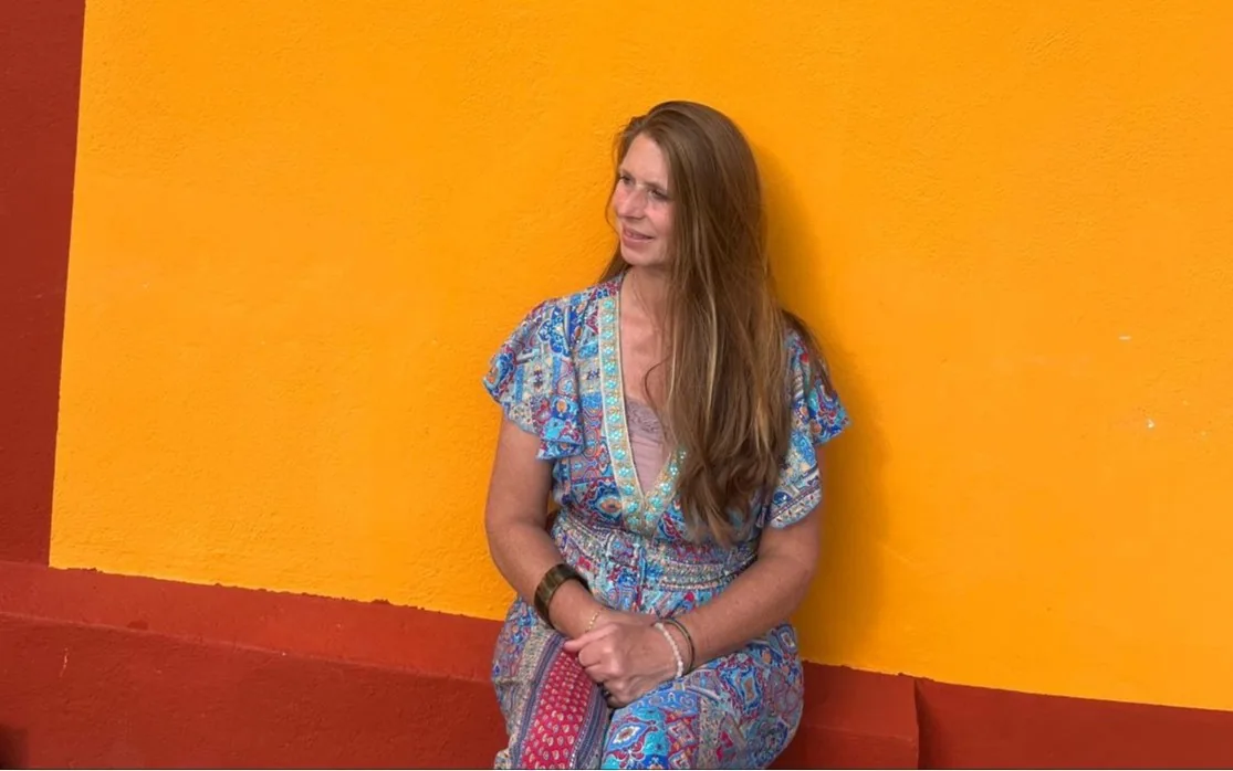 Séverine, thérapeute en Ayurvéda, assise devant un mur ocre